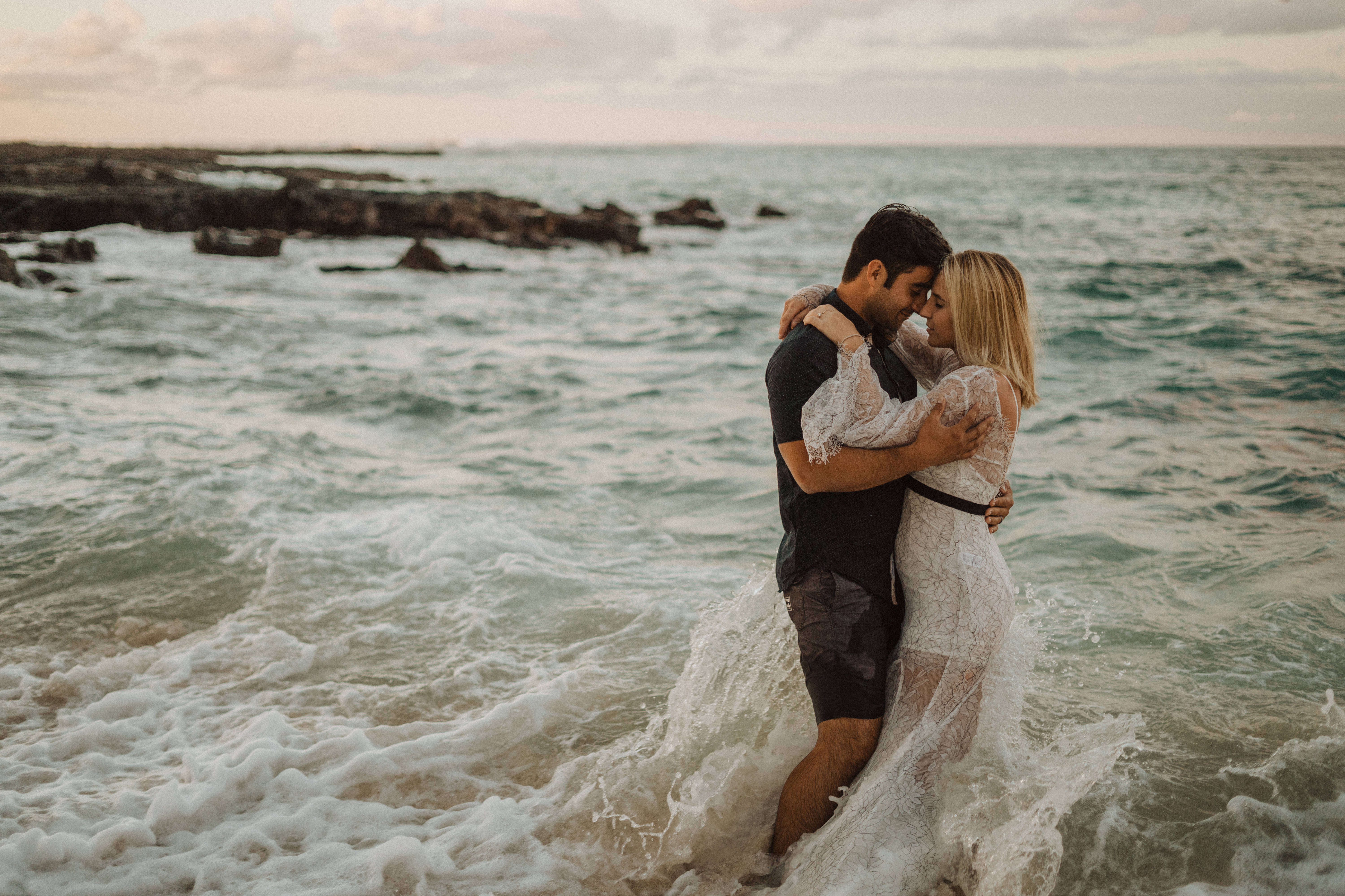 a man and a woman holding each other in the ocean