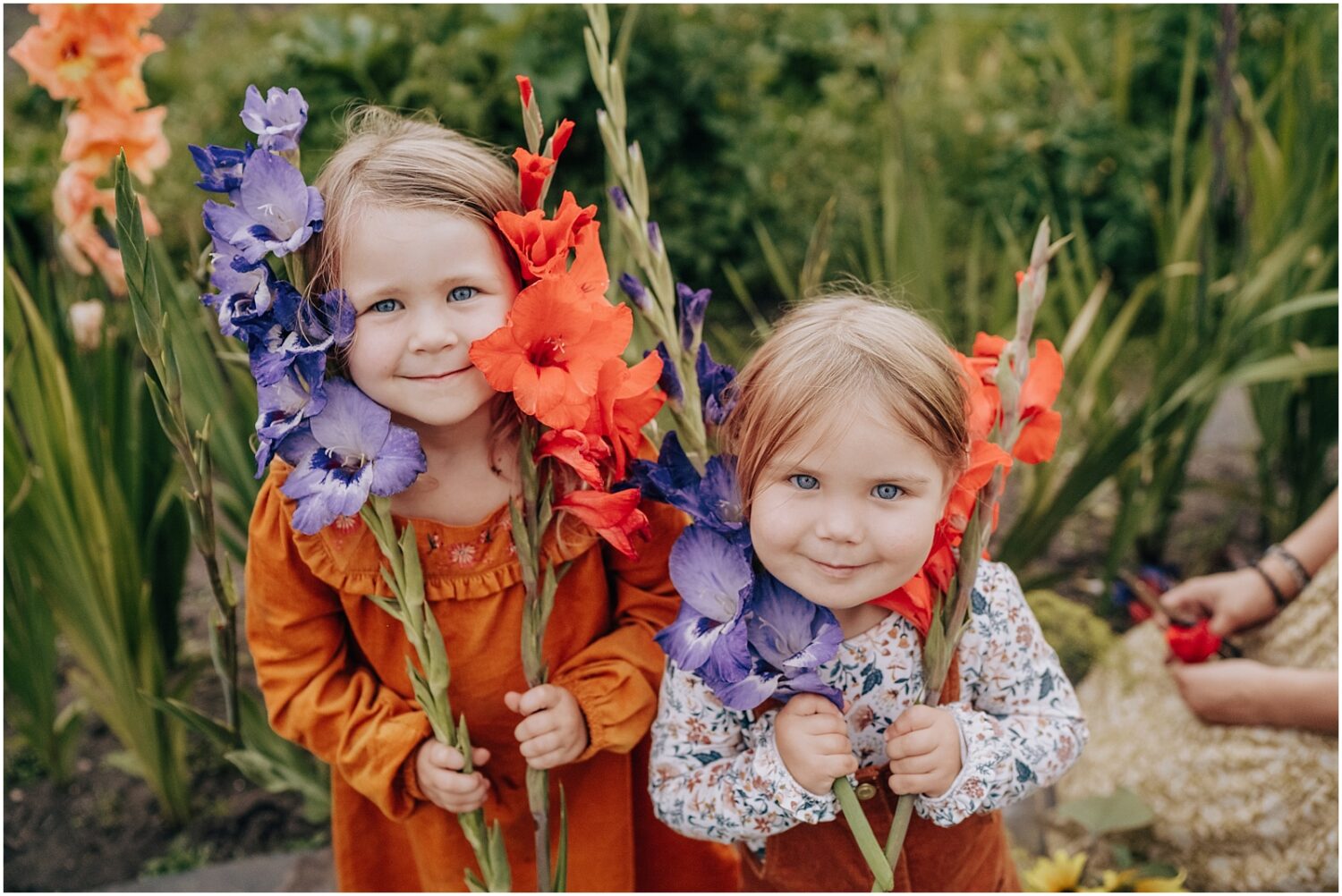 Family in Edmonton with two little gitls holding flowers for a photoshoot