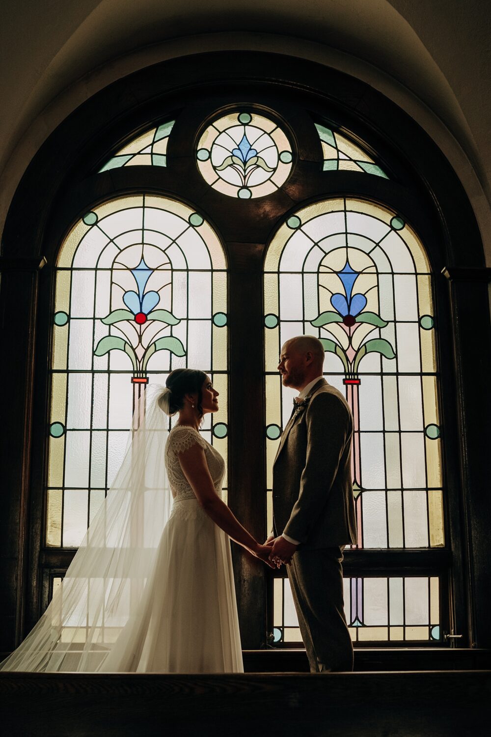 Edmonton wedding photographer bride and groom portraits in front of a stained glass window at McDougall Church