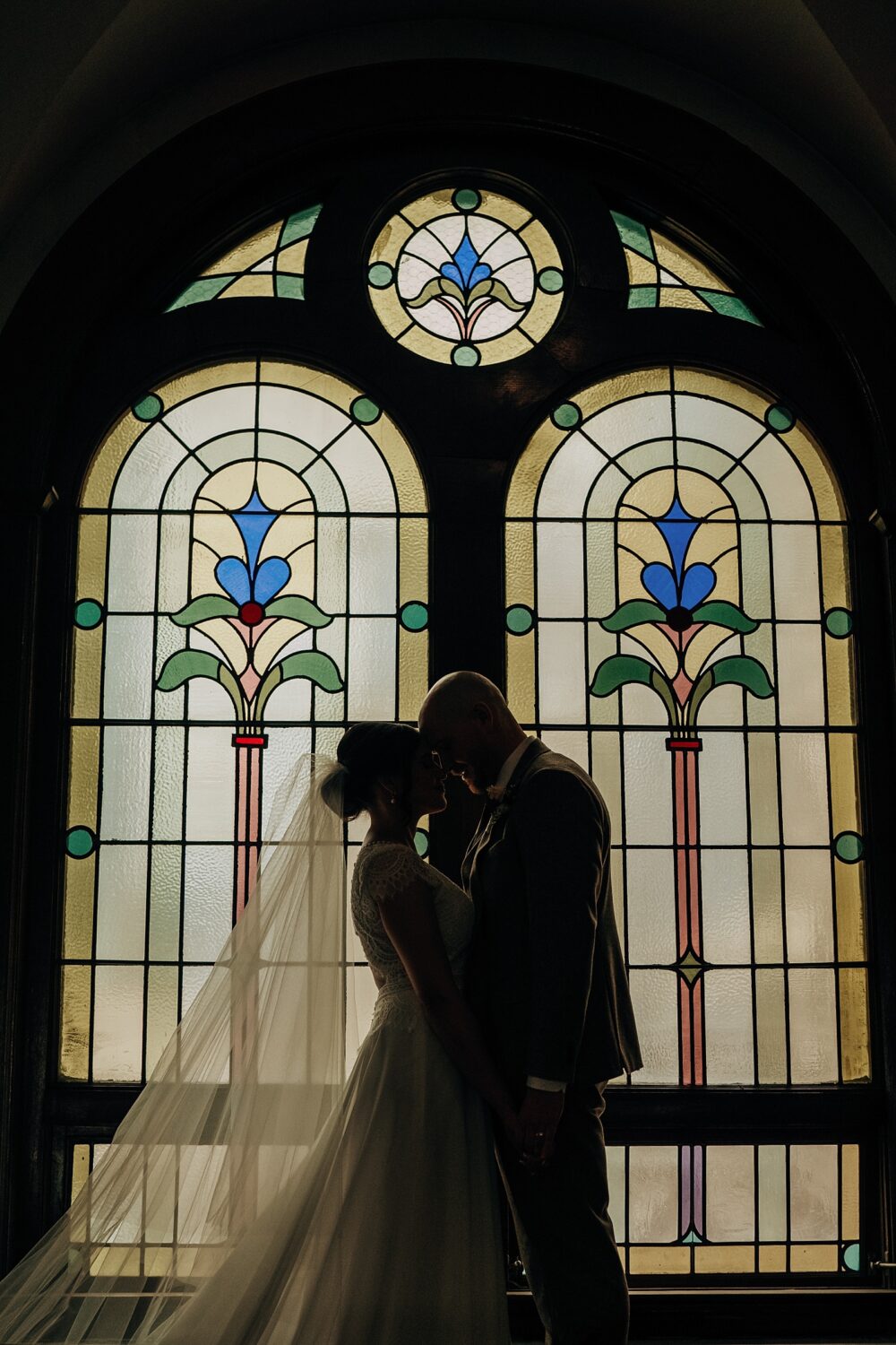 Edmonton wedding photographer bride and groom portraits in front of a stained glass window at McDougall Church